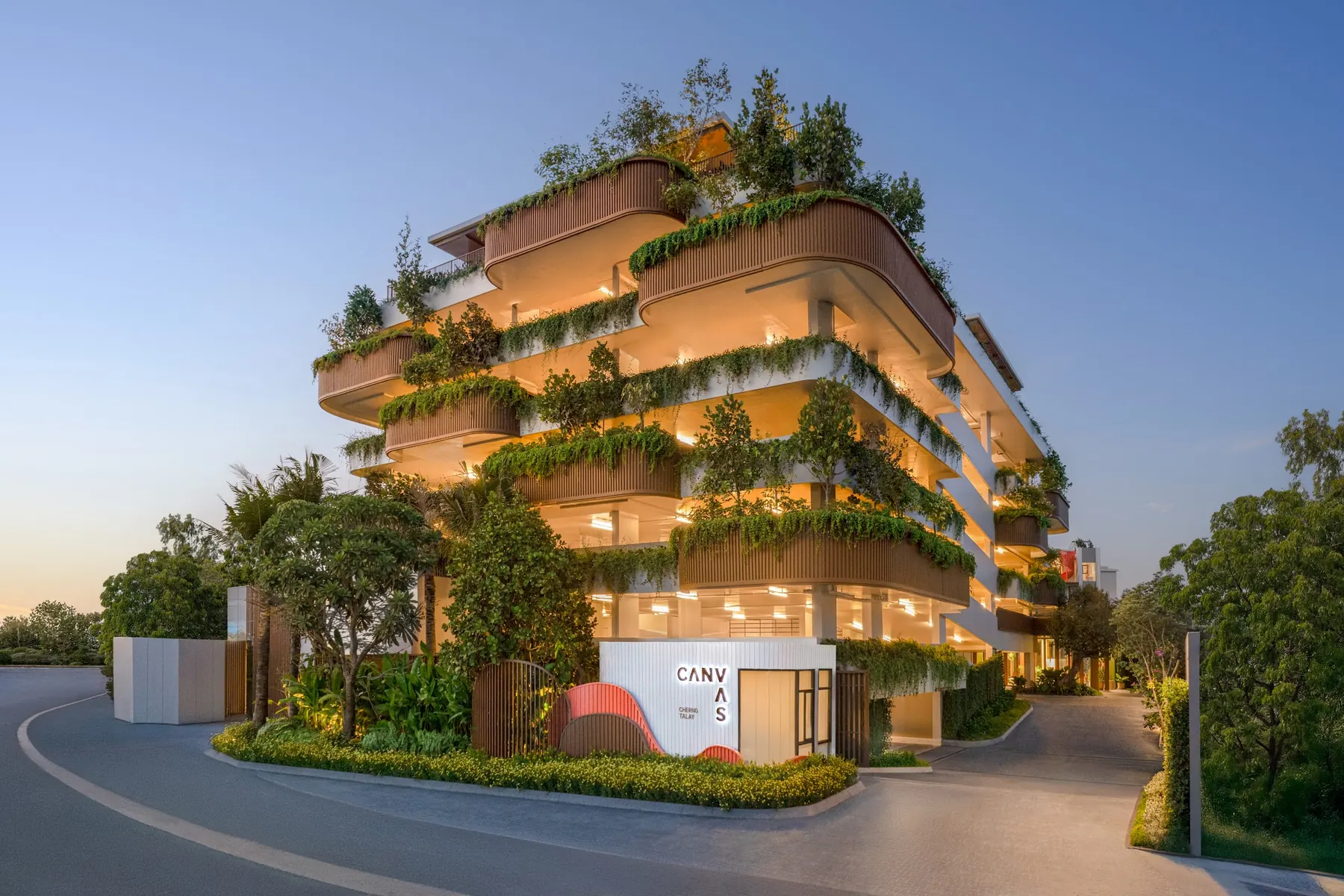 CANVAS Cherngtalay at dusk, its planted balconies lit from within, Phuket